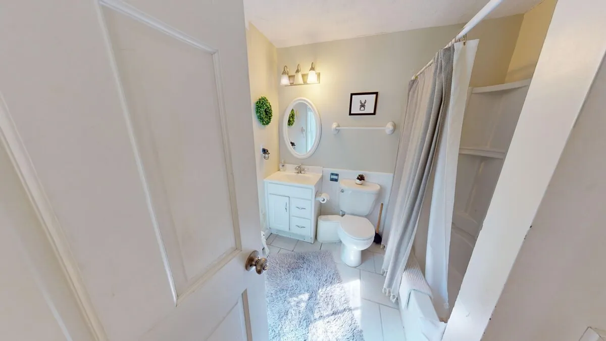 A fresh, well-lit bathroom featuring a stylish vanity with a mirror, greenery for a touch of nature, and cheerful wall art. The space is bright, clean, and designed for relaxation and self-care.